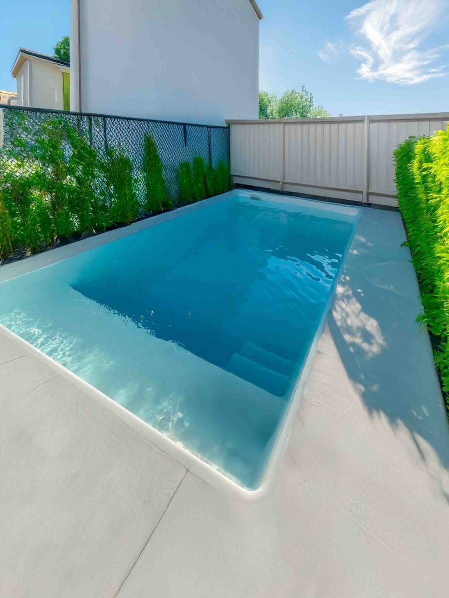 Vue d’ensemble de la piscine Mahina intégrée au jardin à La Ciotat, témoignage d’une intégration parfaite et d’un design moderne.