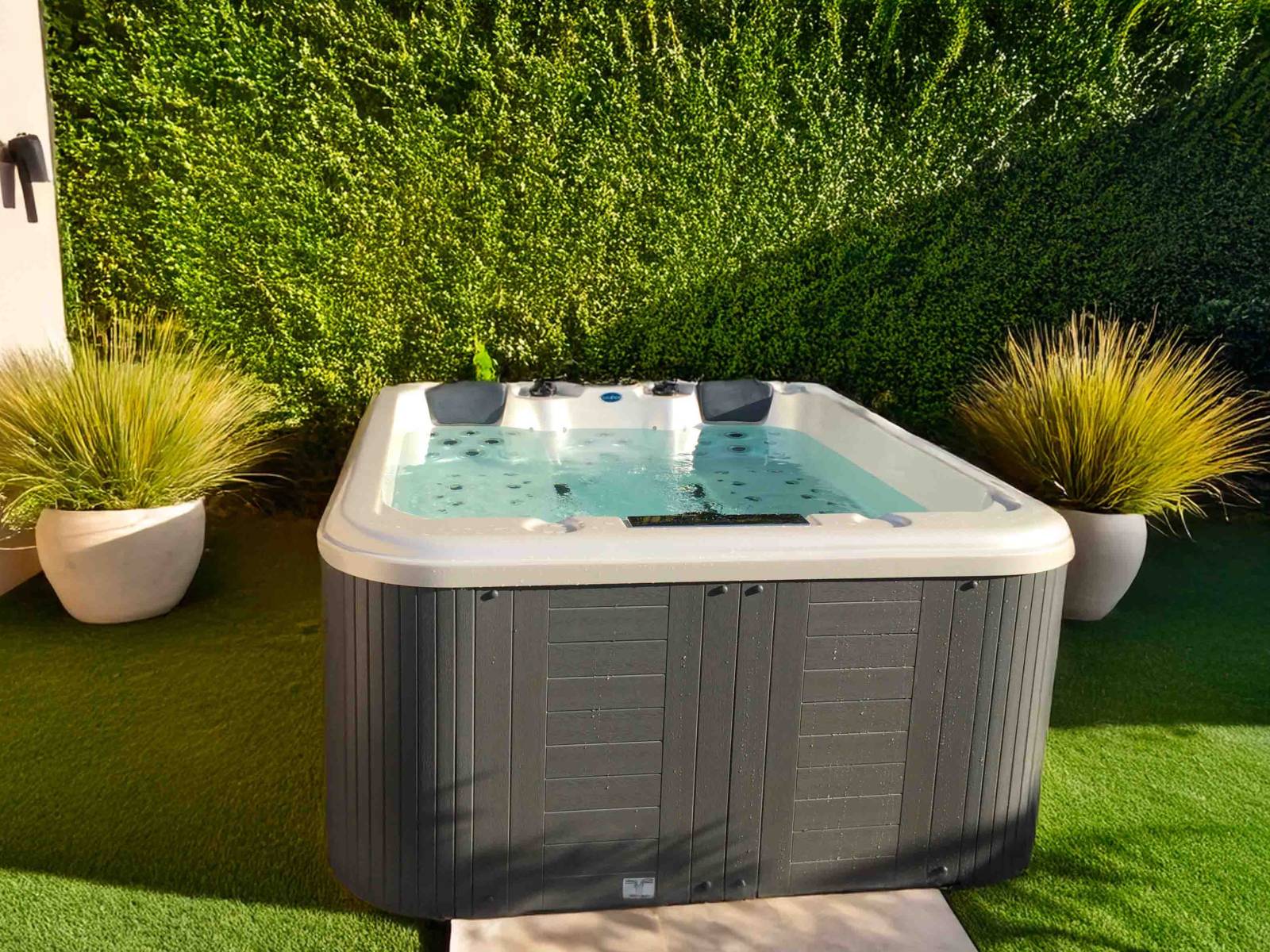 Spa 5 places installé à Port-de-Bouc – modèle Dacca avec coque blanche marbrée et jupe grise, pensé pour une utilisation toute l’année, même pendant l’hiver