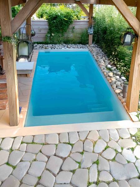 Piscine Mahina installée à Pont-Saint-Esprit – Modèle blanc cristal, intégrée dans un environnement naturel sous abri bois
