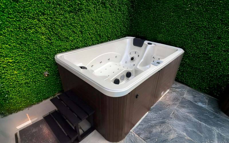 Spa 3 places installé à Allauch – modèle Rio avec jupe marron et coque blanche, intégré dans un coin détente végétalisé