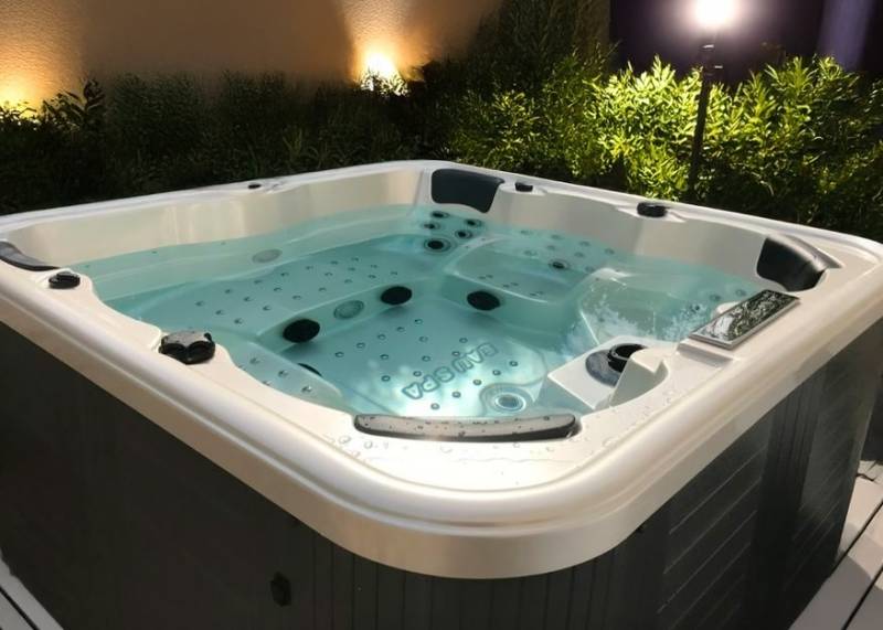 Spa 6 places installé à Saint-Gilles – modèle Cuba sur terrasse bois, intégré avec jupe grise et coque blanche marbrée